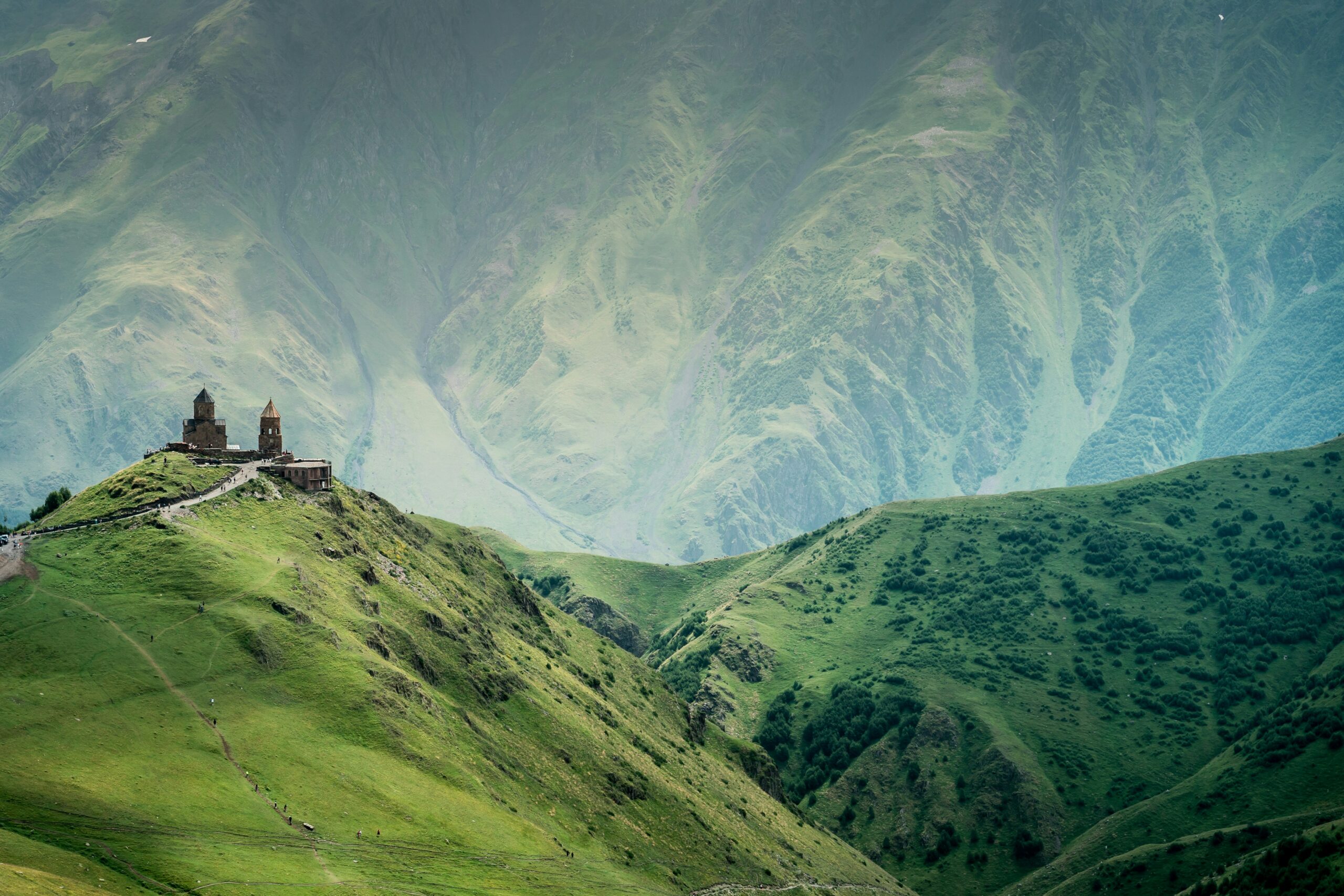 Paesaggio naturale del Caucaso, con una casa in cima ad un'altura verde